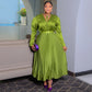 Olive green high shine pleated maxi dress with tie neck and matching belt, worn indoors
