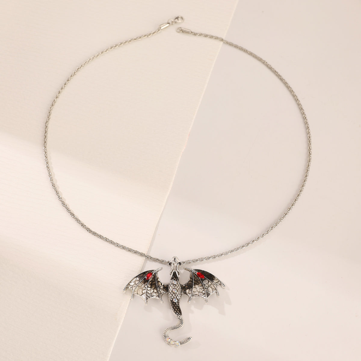 Retro dragon pendant styled and layered against a neutral top