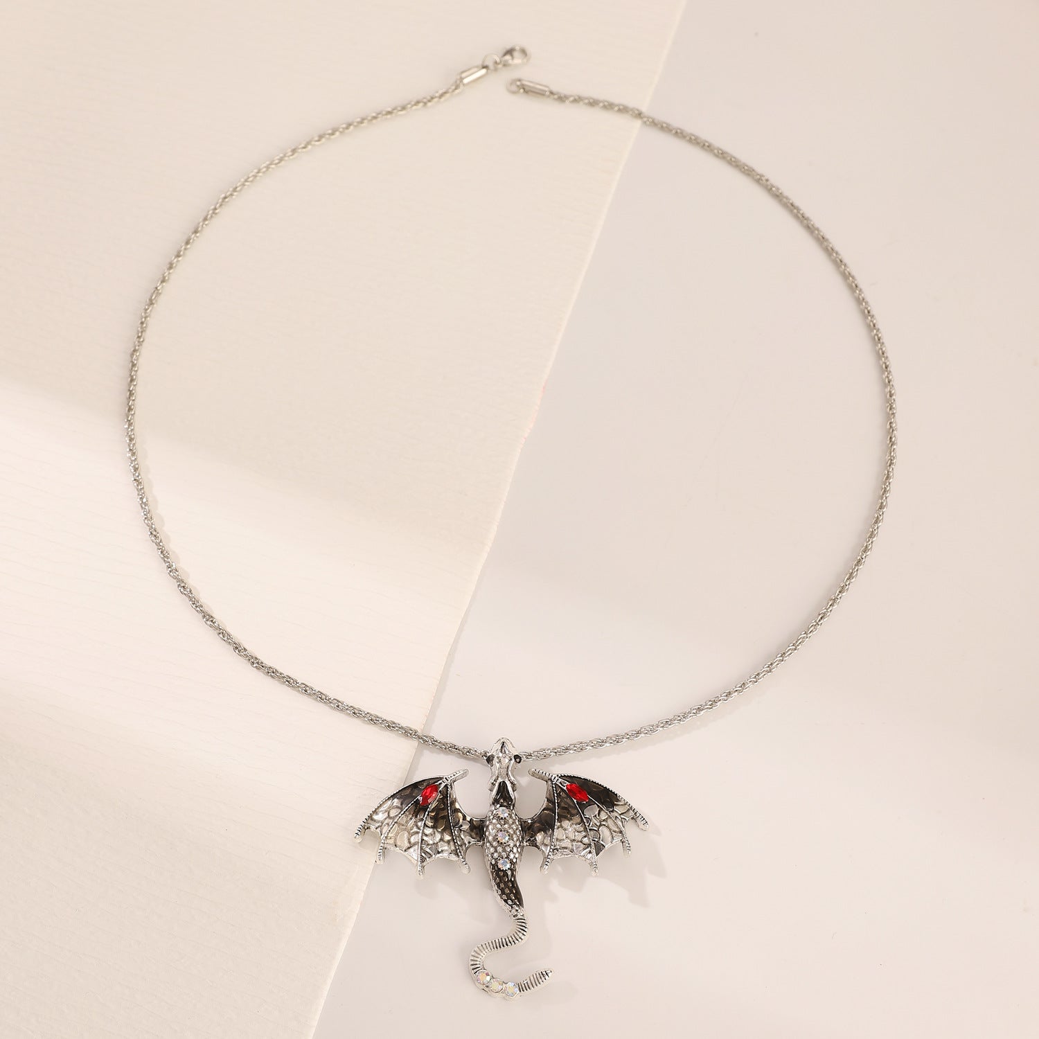 Retro dragon pendant styled and layered against a neutral top