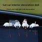 Four white and grey cat figurines fishing from the top edge of a car centre screen
