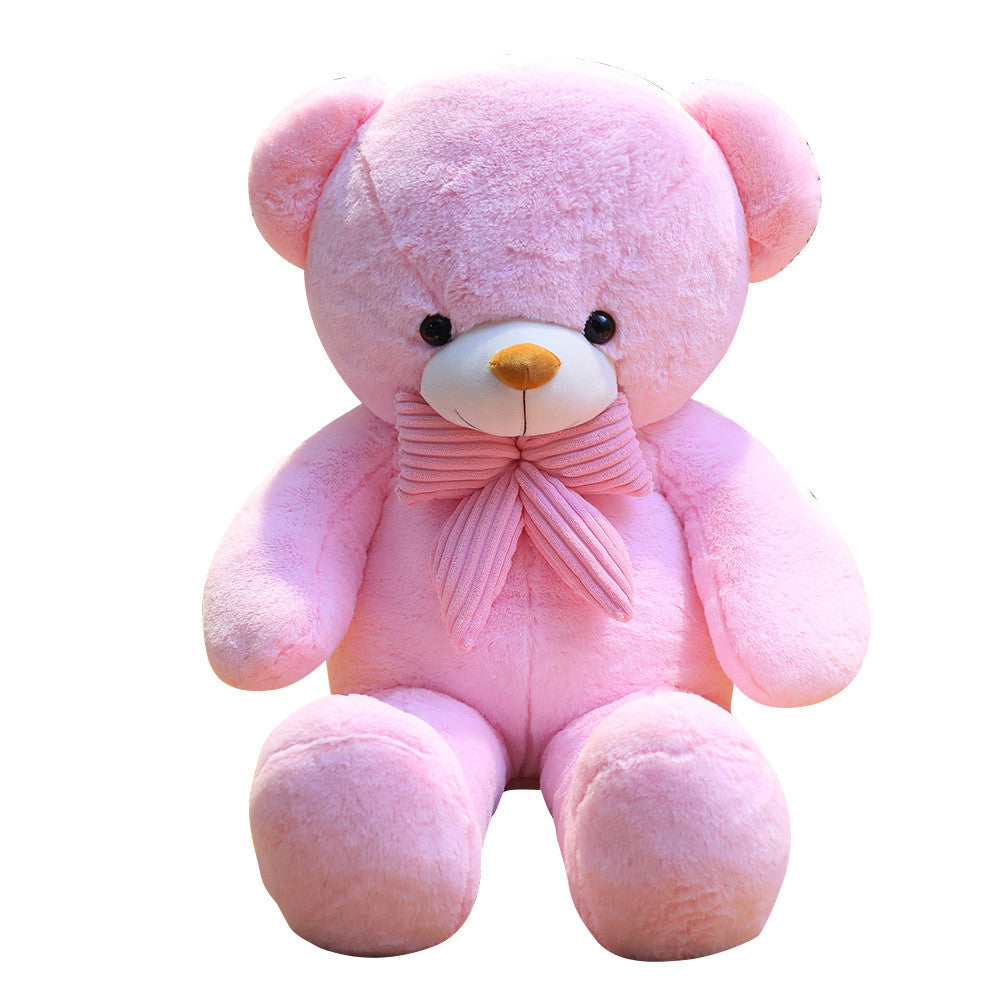 Pink plush teddy bear with a pink striped bow tie sitting on a white background