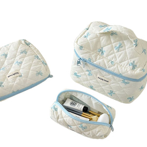 Large capacity bow makeup bag shown open with items inside