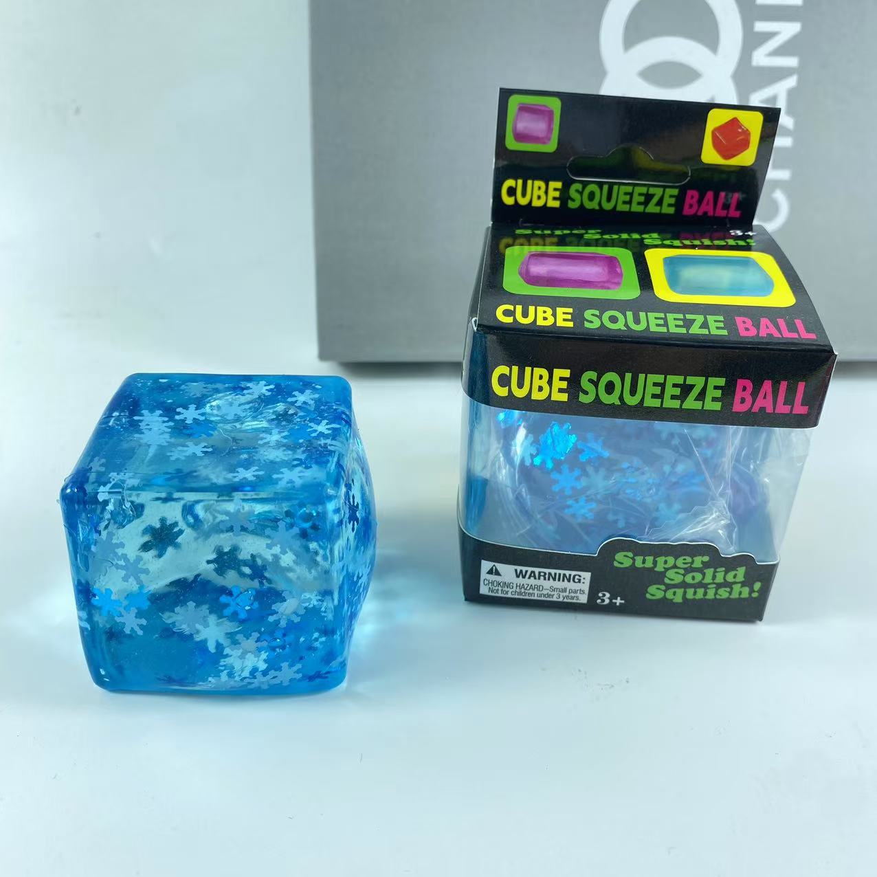 Set of blue gel snowflake cube squishy toys in several sizes on a plain background