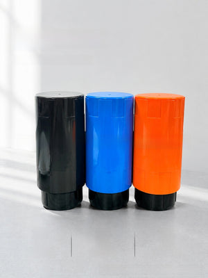 Black, blue and orange tennis ball pressurizer tubes standing side by side