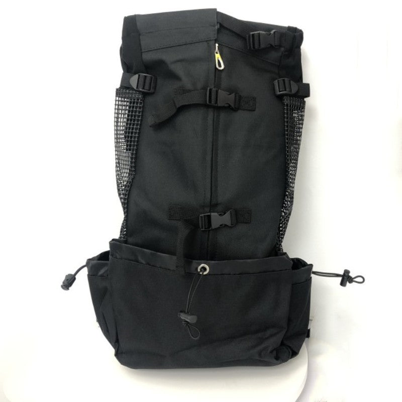 Black Oxford fabric dog carrier backpack showing mesh side vents and buckle straps