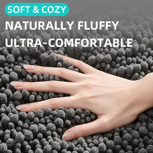 Gray chenille bath mat pile with a hand resting on the fluffy surface, close up