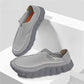 Light gray perforated slip-on loafers with a slate gray scalloped sole and an orange insole on a white stepped set