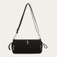 Black cylindrical nylon crossbody bag with silver zipper pulls and a long adjustable strap on a plain background