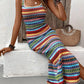 Bright striped knit maxi dress seated, showing the openwork tribal bands and double straps, front view
