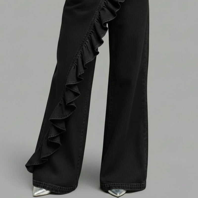 Black wide leg denim trousers with a cascading diagonal ruffle running down the front leg