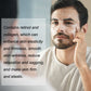 Man smoothing face cream onto his cheek in front of a bathroom mirror
