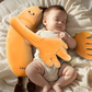 Baby soothing plush pillow next to a hand for size reference
