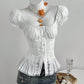 White puff sleeve blouse styled on a dress form, square neckline levelled and pleated peplum at the hip