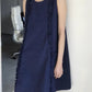Navy blue loose A-line ruffle trim dress worn sleeveless, front three-quarter view