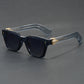 Glossy black square sunglasses with wide temples and a gold arrowhead at the hinge