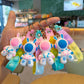 Four astronaut rabbit charms fanned out on silicone push pop straps in pink and blue pastel colors