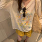 Front of ivory floral long sleeve tee showing draped neckline and blooms print