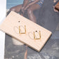 Pair of gold U shaped non pierced ear cuffs on a wood display block