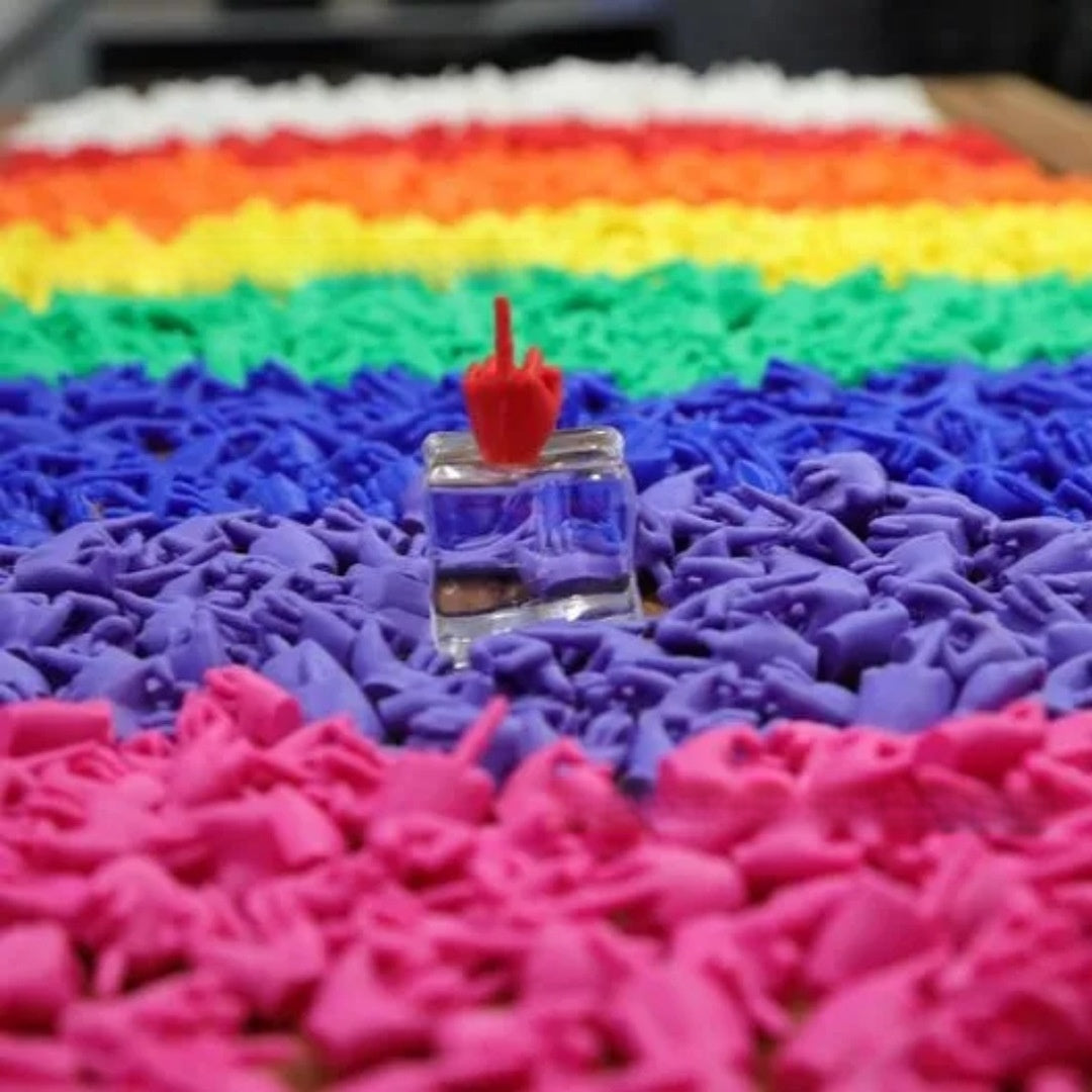 Rainbow trays of moulded novelty hand figures with one red piece standing on a clear glass block