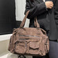 Mocha brown PU shoulder bag on the arm showing front zip pockets, a small zipped pouch and a flap pocket
