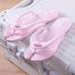 Foldable EVA travel slippers resting on a hard shell suitcase in a hotel setting