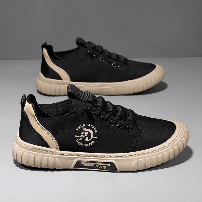 Pair of black lace up canvas sneakers with a beige ribbed sole and a beige heel stripe on a gray backdrop