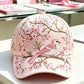 Curved brim floral print cap seen from the front on a soft pale surface