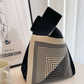 Two tone jacquard knit handbag carried by a built in wrist loop handle