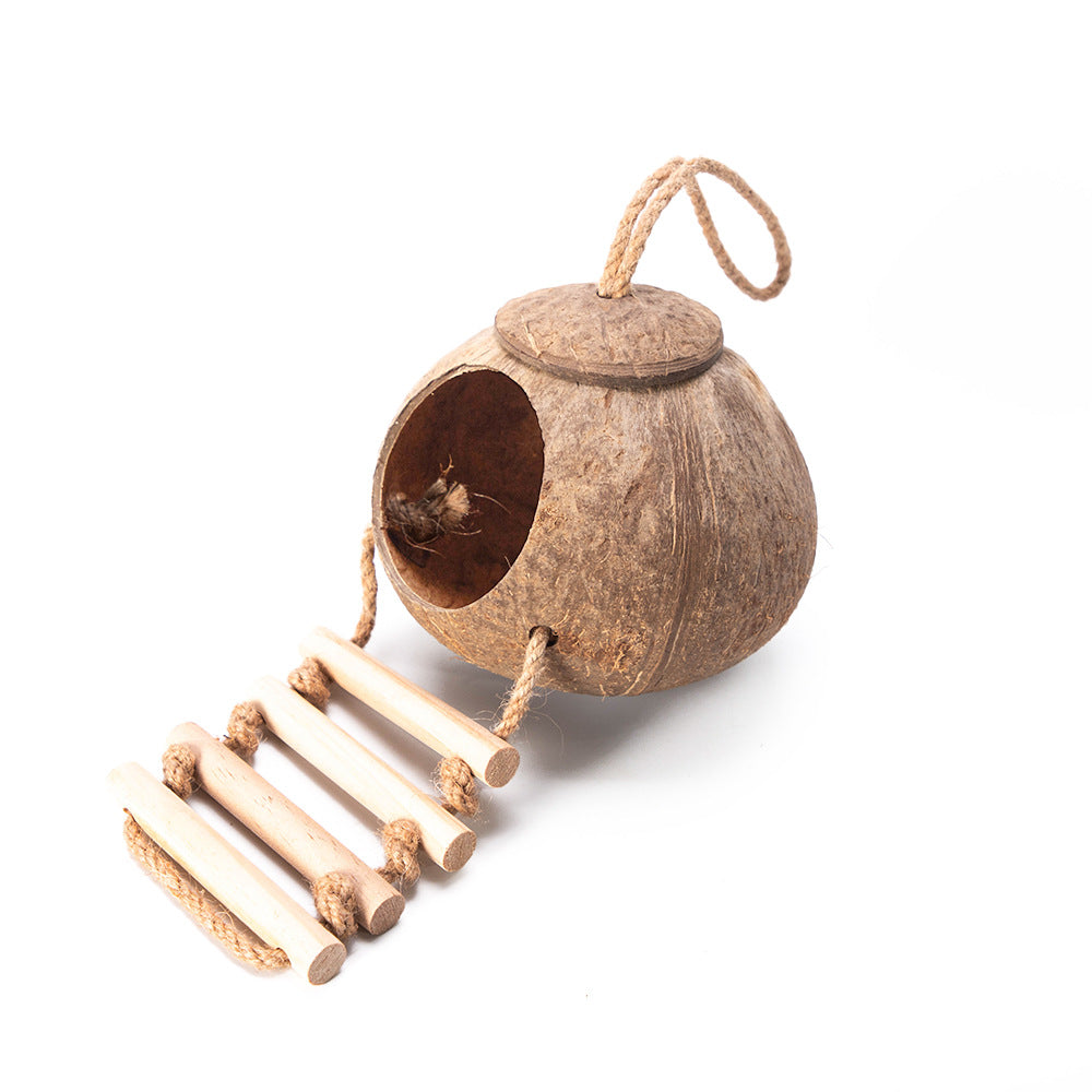 Coconut shell reptile hideout with a wooden rope ladder inside an enclosure