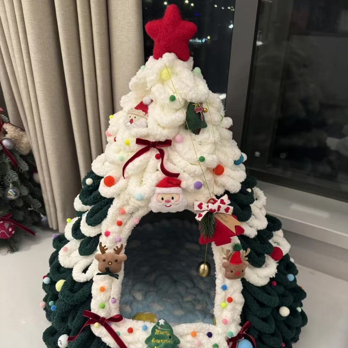 Close view of the green and white chenille pet house with an arched doorway and a soft blue interior