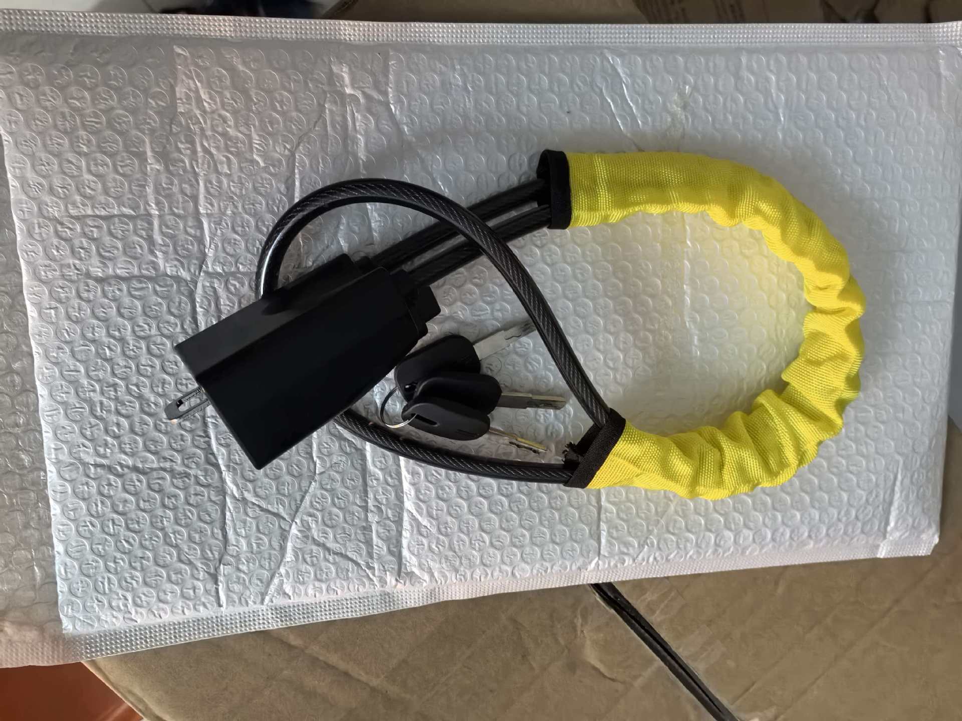 Steering wheel cable lock securing a seat belt buckle in a car