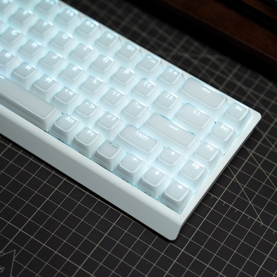 Translucent keycap M68 keyboard showing the arrow cluster lit on a dark surface