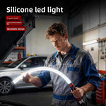 Flexible silicone LED work light bent around a car engine bay by a mechanic