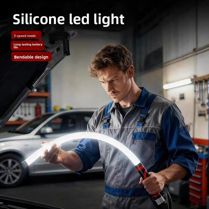 Flexible silicone LED work light bent around a car engine bay by a mechanic