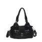 Black washed denim shoulder bag laid flat with buckle flap and silver studs