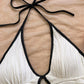 Halter neck bodycon romper in white rippled stretch fabric with a self tie bow and keyhole cutout