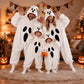 Four people in matching white plush ghost onesies striking spooky poses in a Halloween decorated room