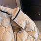 Close view of the ribbed stand collar and black stripe on a khaki quilted bomber jacket