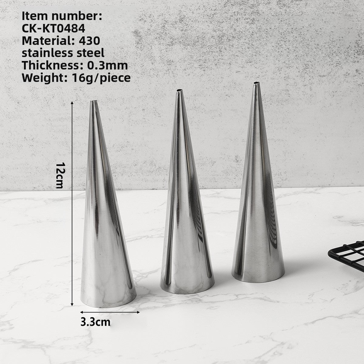 Three stainless steel cone pastry molds 12 cm tall with a 3.3 cm base on a marble surface