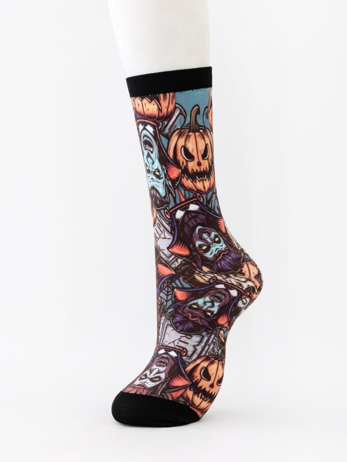 Mid-calf sock on a mannequin printed with a collage of grinning pumpkins and monster masks