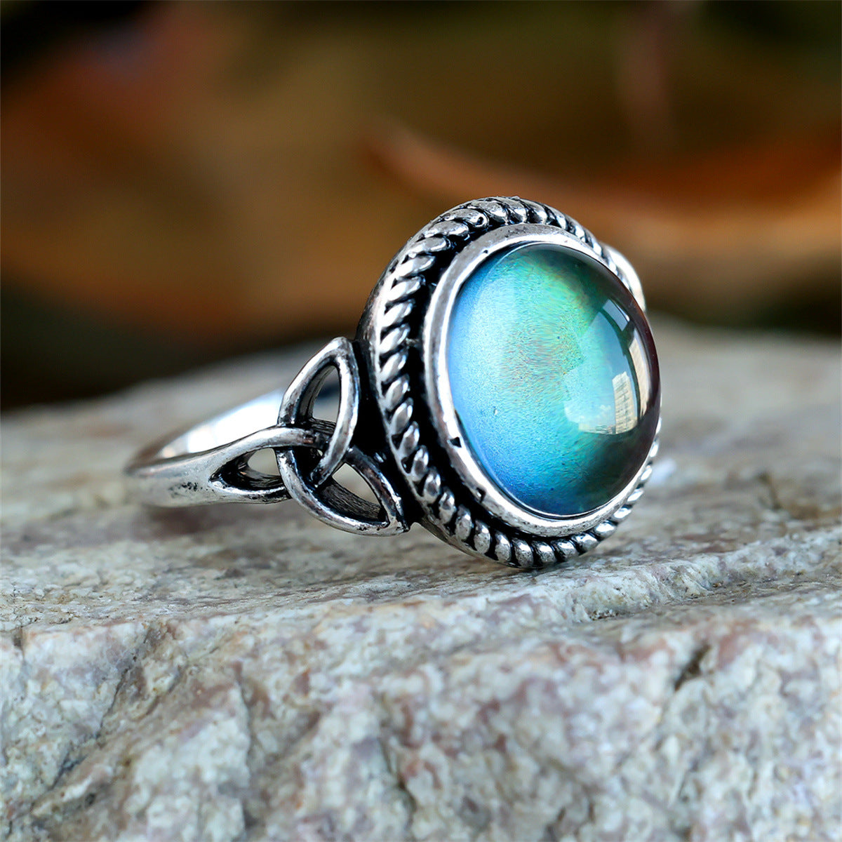 Side view of mood ring showing Celtic trinity knot shoulder and blue green cabochon