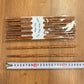 Pack of coconut wood chopsticks with two loose chopsticks beside a tape measure, chopsticks option photo