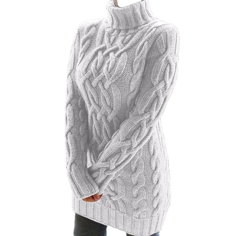 White chunky cable knit turtleneck sweater dress on a model with a fold-over collar and ribbed hem