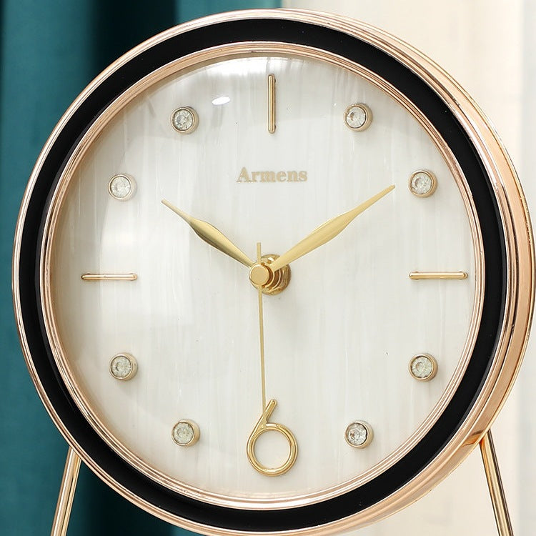 Close view of a white shell pattern clock dial with gold hands, crystal style hour studs and a gold looped second hand