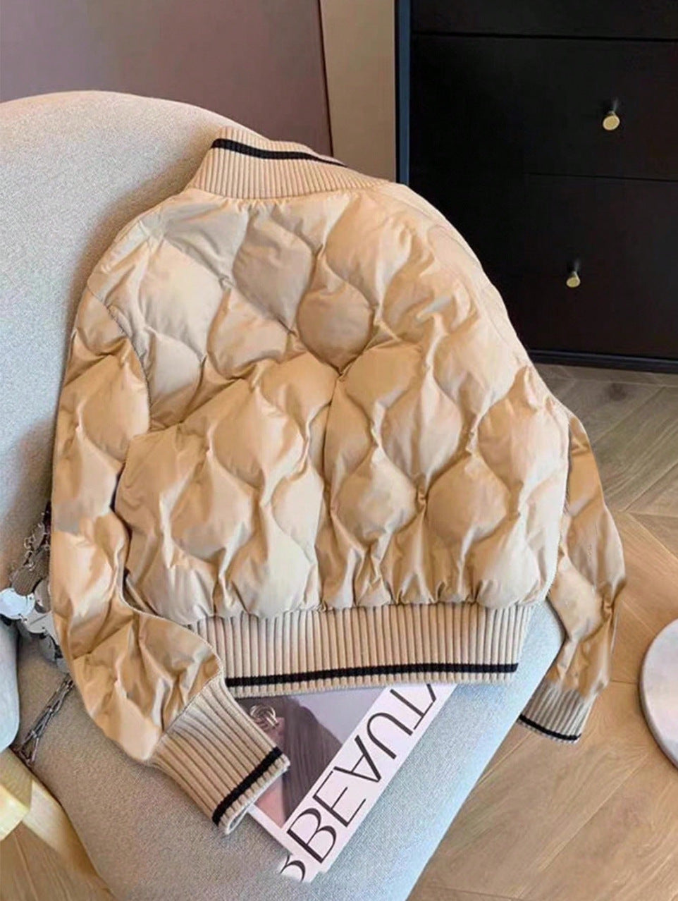 Quilted khaki jacket with a ribbed stand collar edged in a black stripe, varsity style