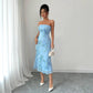 Full length front view of the sky blue ribbon embroidered strapless dress beside a white curtain
