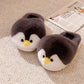 Pair of dark gray plush penguin slippers with yellow beaks and black eyes on a beige rug beside a newspaper, Gray Open-Heel