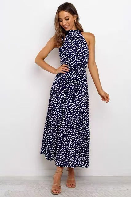 Navy polka dot halter neck sleeveless tiered swing maxi dress worn by a model