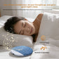 Grey fabric pillow speaker lying flat on a white sheet next to a pillow
