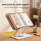 Open book on the wide wood grain board of a rotating reading stand on a wooden desk beside a pen and cup